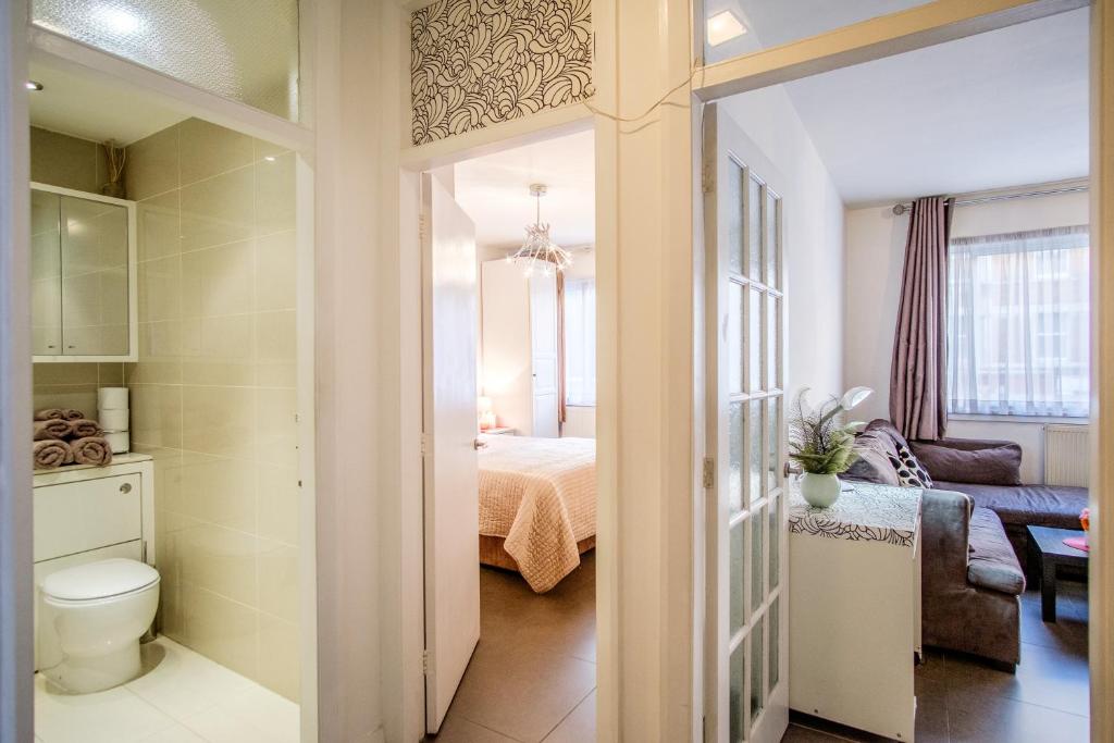 a bathroom with a toilet and a room with a bed at Quality Stylish Flat in Russell Square in London