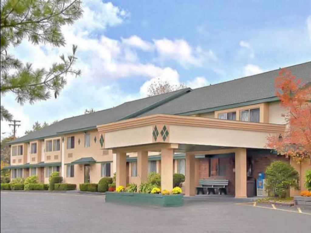 a large building with a bench in a parking lot at Americas Best Value Inn New Paltz in New Paltz