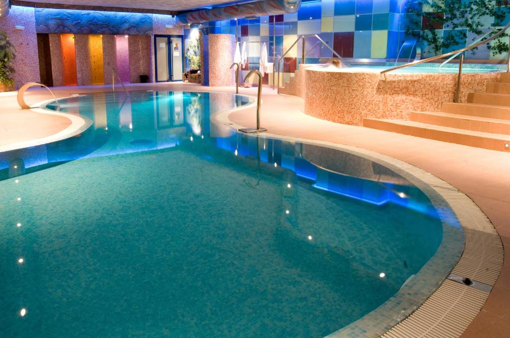 a swimming pool with blue water in a hotel at Spa Hotel Ciudad de Teruel in Teruel