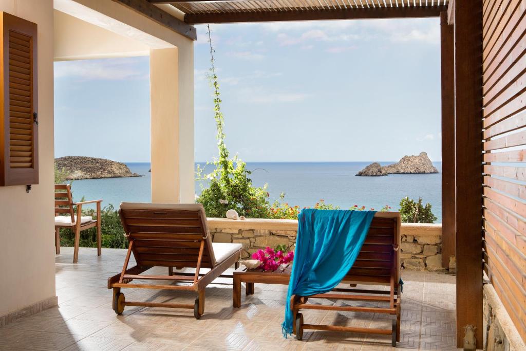 dwa krzesła na werandzie z widokiem na ocean w obiekcie Natica Mare Villas w mieście Xerokampos