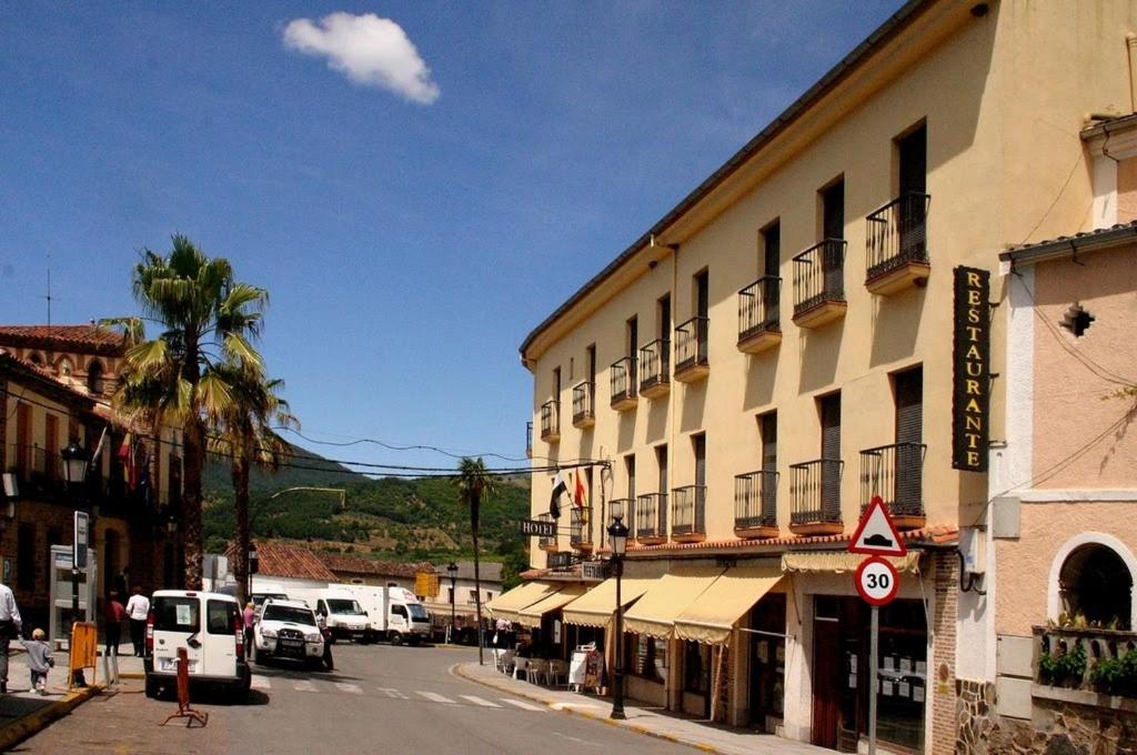 une rue de la ville avec un bâtiment et un palmier dans l'établissement Hotel Hispanidad, à Guadalupe