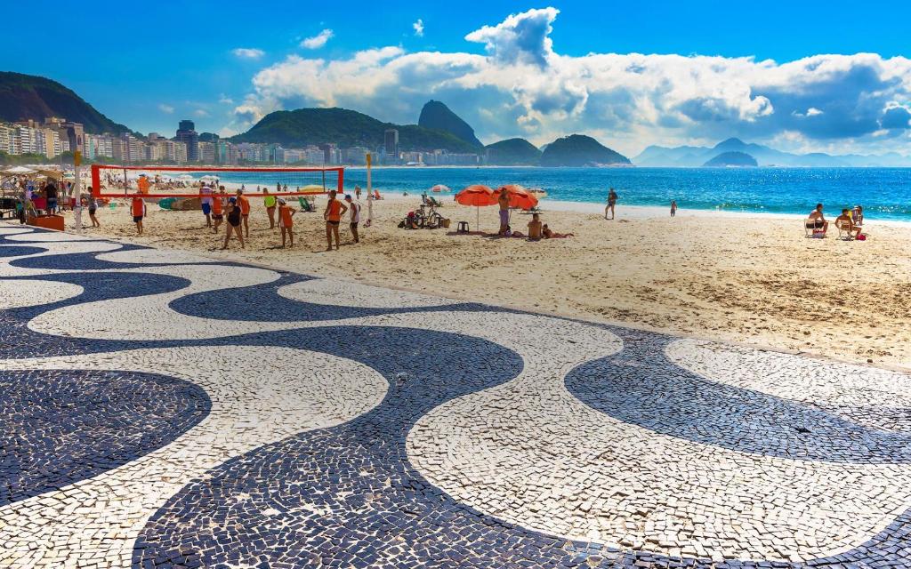 uma vista para uma praia com pessoas na praia em Apartamento Copacabana no Rio de Janeiro