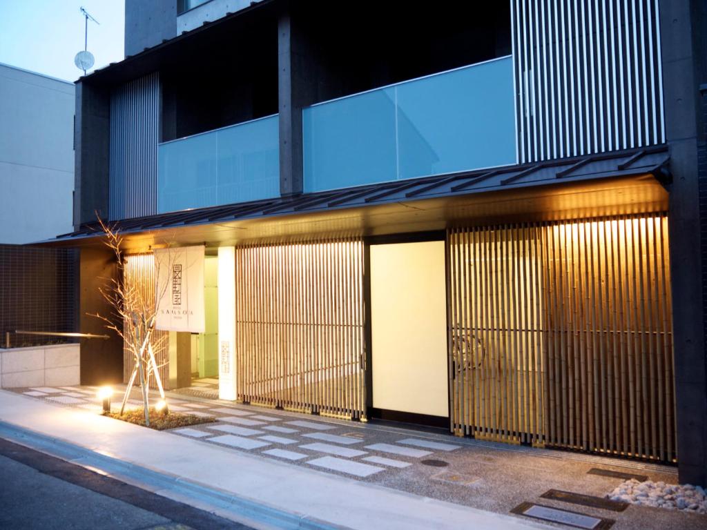 a building with doors with a tree in front of it at Naganoya in Kyoto