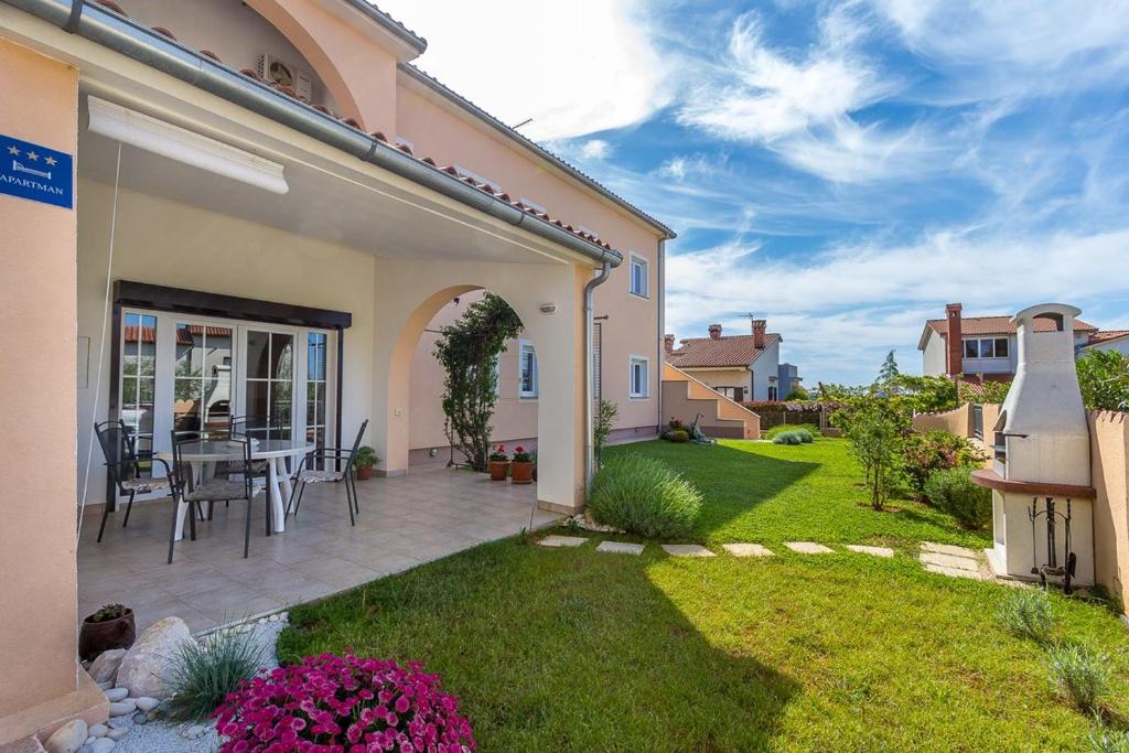 a patio with a table and chairs in a yard at Apartment Jasna in Vinkuran