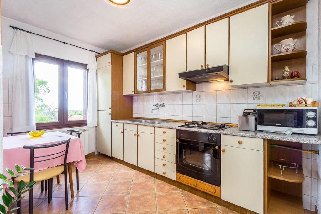 kuchnia z kuchenką i stołem w obiekcie Apartment Stelia w mieście Mednjan