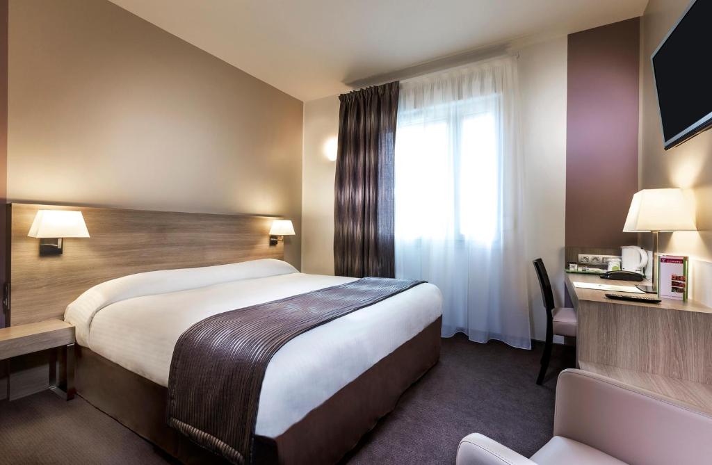 um quarto de hotel com uma cama e uma janela em Campanile Metz Nord - Talange em Talange