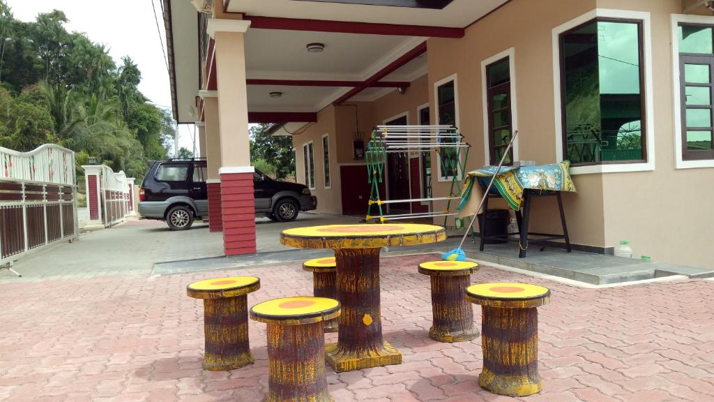 a table and stools in front of a building at DBukit Losong Villa Kuala Terengganu in Kuala Terengganu