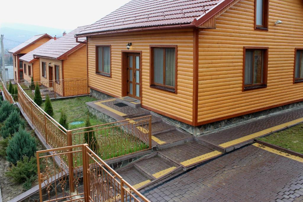rząd drewnianych domków w szeregu w obiekcie Solnce Karpat w mieście Polyana (Polana)