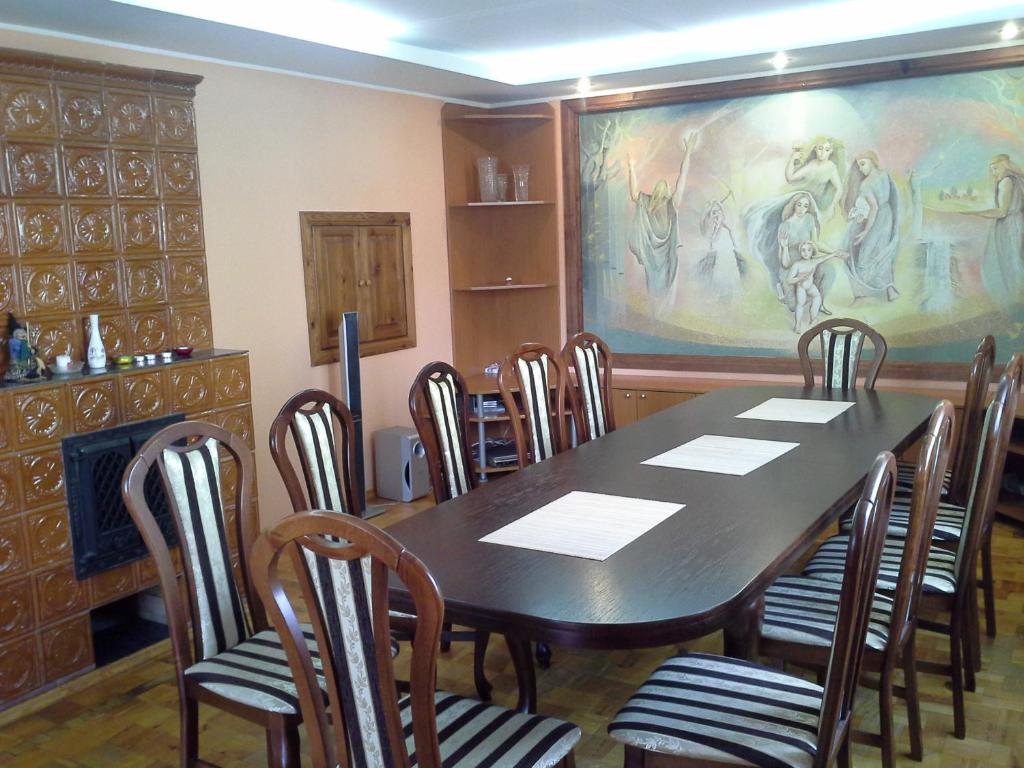 een eetkamer met een tafel en stoelen en een schilderij bij Lima in Druskininkai