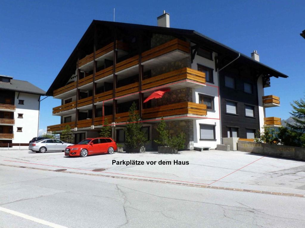 um edifício com um carro vermelho estacionado em frente dele em IMMEUBLE Panorama em Les Collons