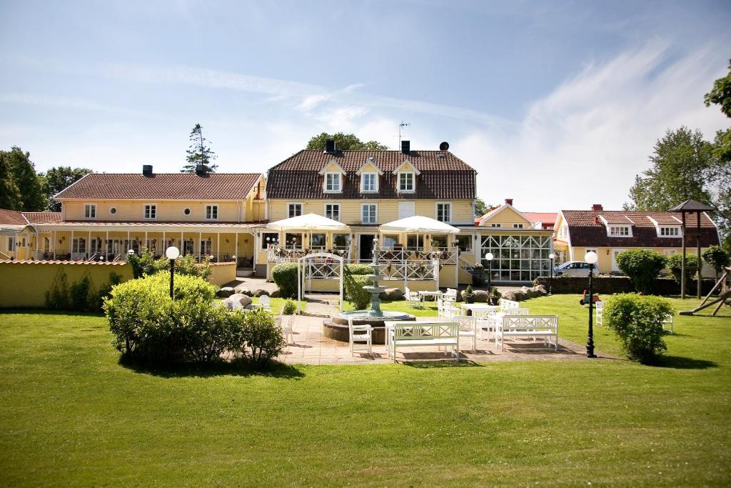 ein großes Haus mit Rasen davor in der Unterkunft Hotel Skansen in Färjestaden