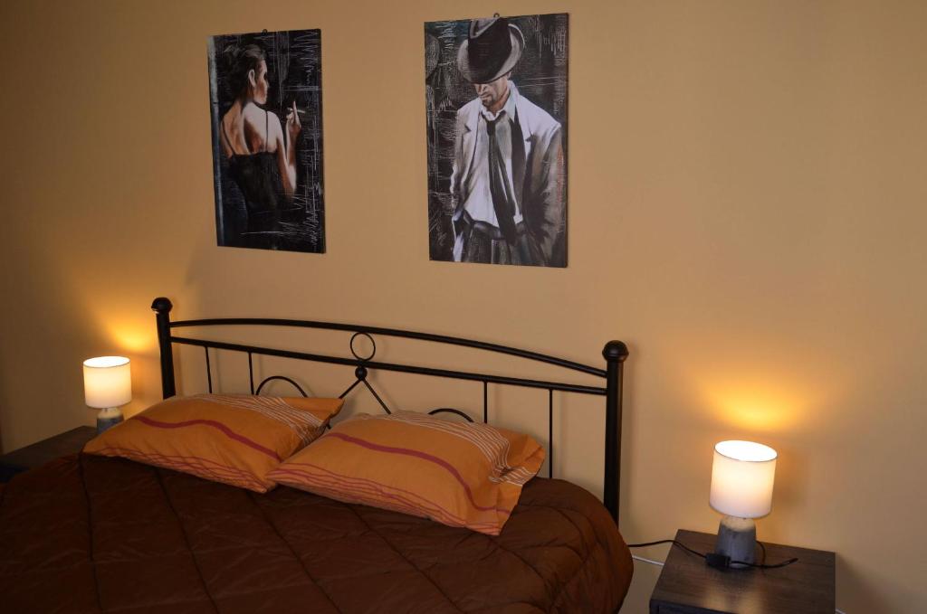 a bedroom with a bed and two pictures on the wall at Kalimera Apartment in Nafplio