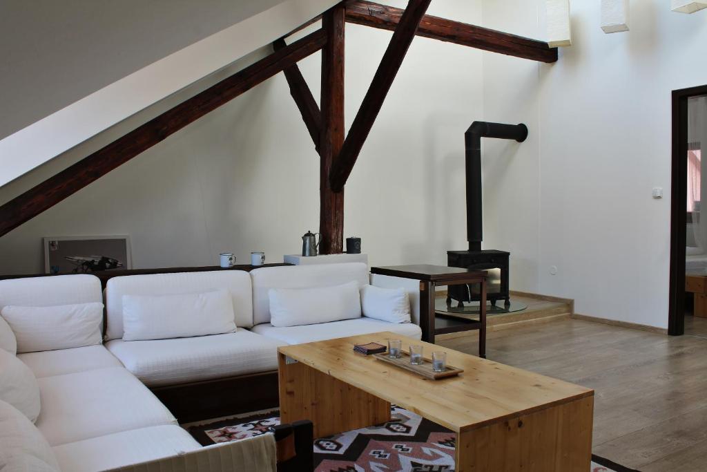 a living room with a white couch and a wooden table at Attic with parking, near the center of ČB - 110m2 in České Budějovice
