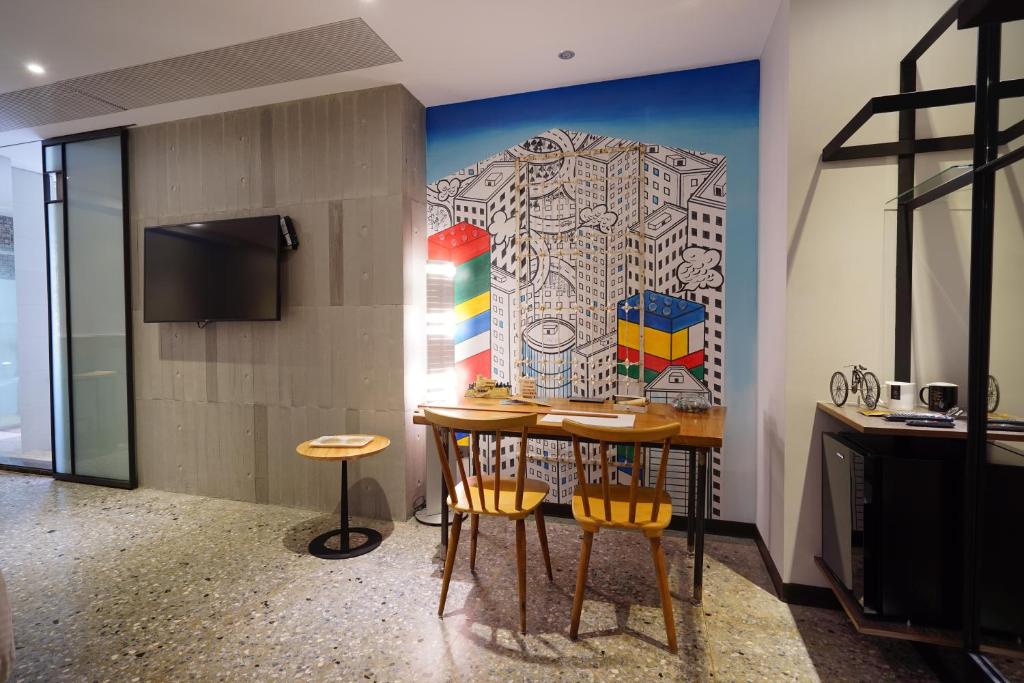 a dining room with a table and chairs and a mural at 3 Door Hotel in Tainan