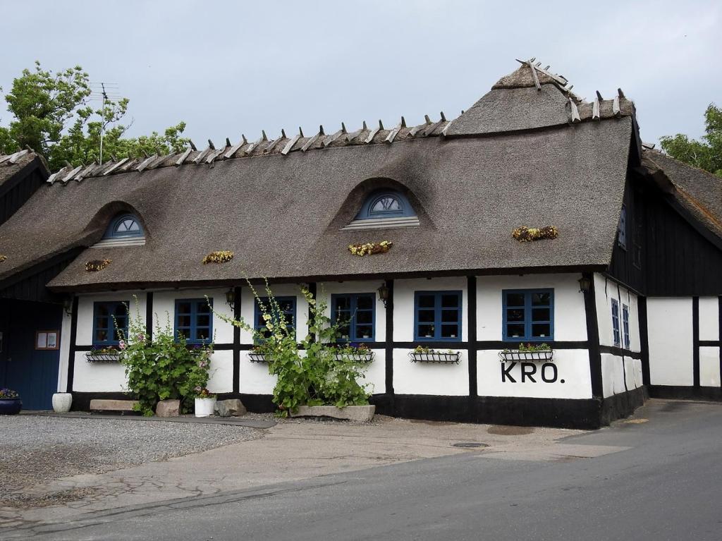 un edificio blanco y negro con techo negro en Reersø Kro, en Reersø