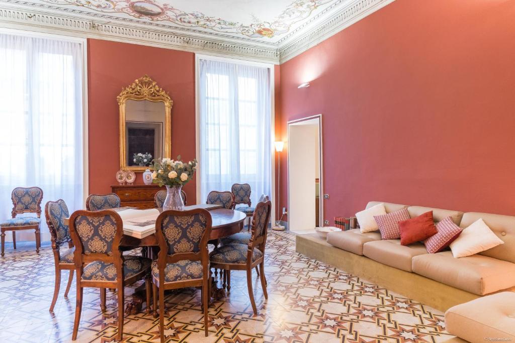 ein Esszimmer mit einem Tisch und einem Sofa in der Unterkunft La Chaise Longue in Lucca