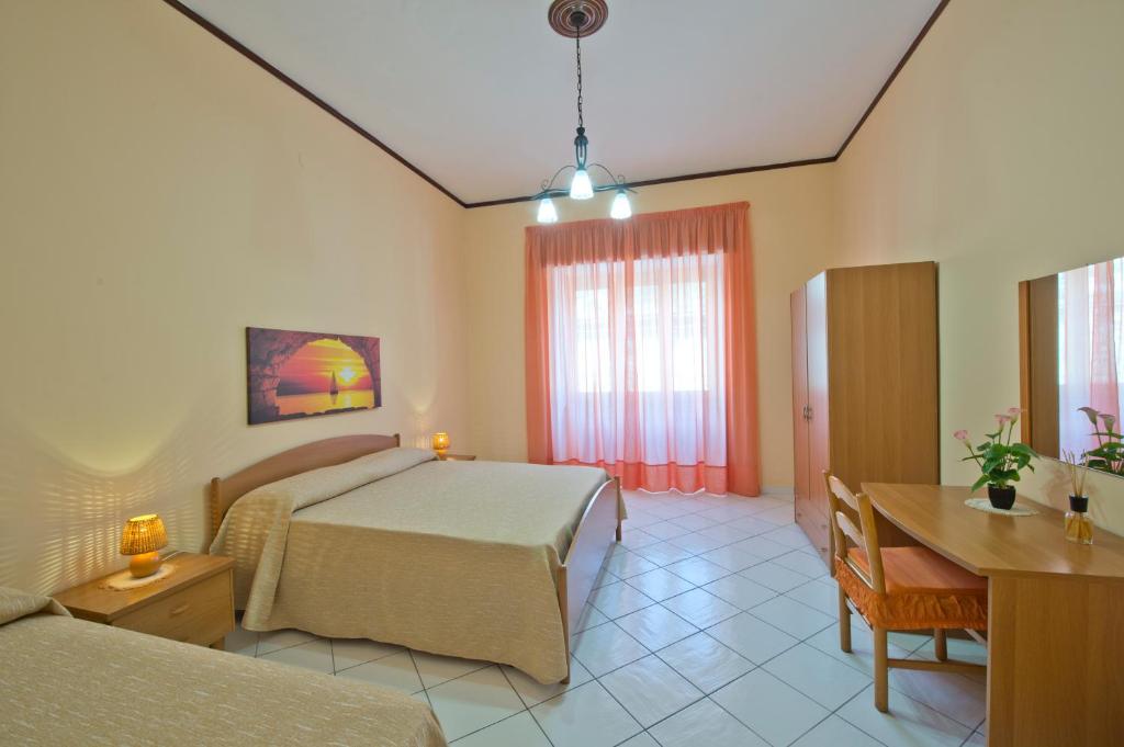 a bedroom with two beds and a table and a desk at Casa Generosa in Agerola