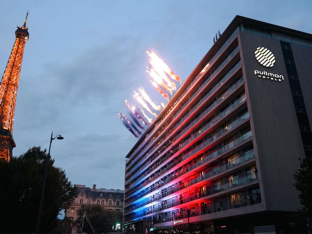 Pullman Paris Tour Eiffel hotel exterior beside the illuminated Eiffel Tower