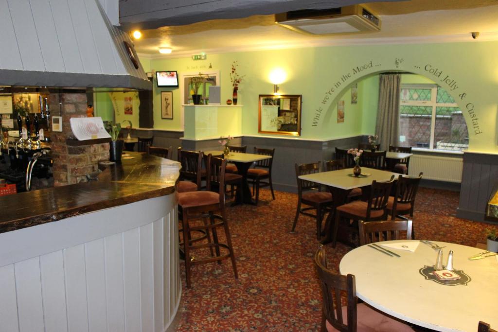 um restaurante com mesas e cadeiras e um bar em Oliver Twist Country Inn em Wisbech