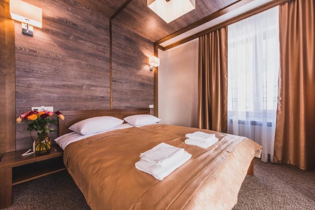 1 dormitorio con 1 cama grande y toallas. en Davir Spa Resort, en Lumshory