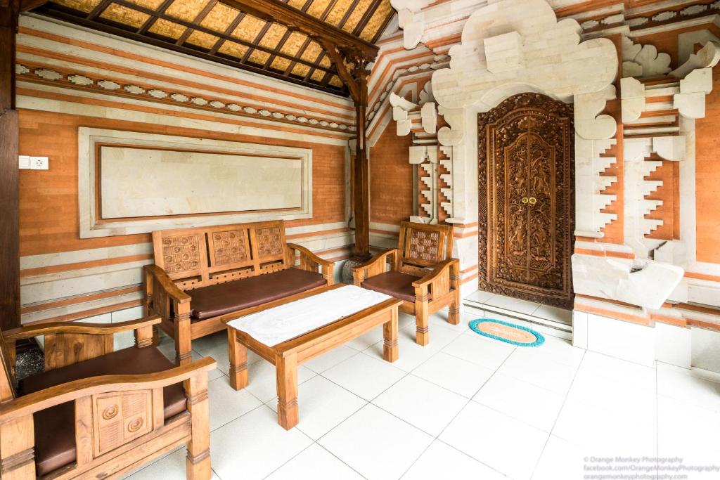 a room with three benches and a large screen at Sudiana House in Ubud