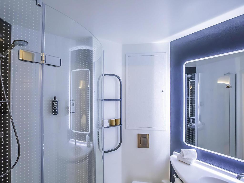 A bright bathroom with a glass-enclosed shower and illuminated mirror.