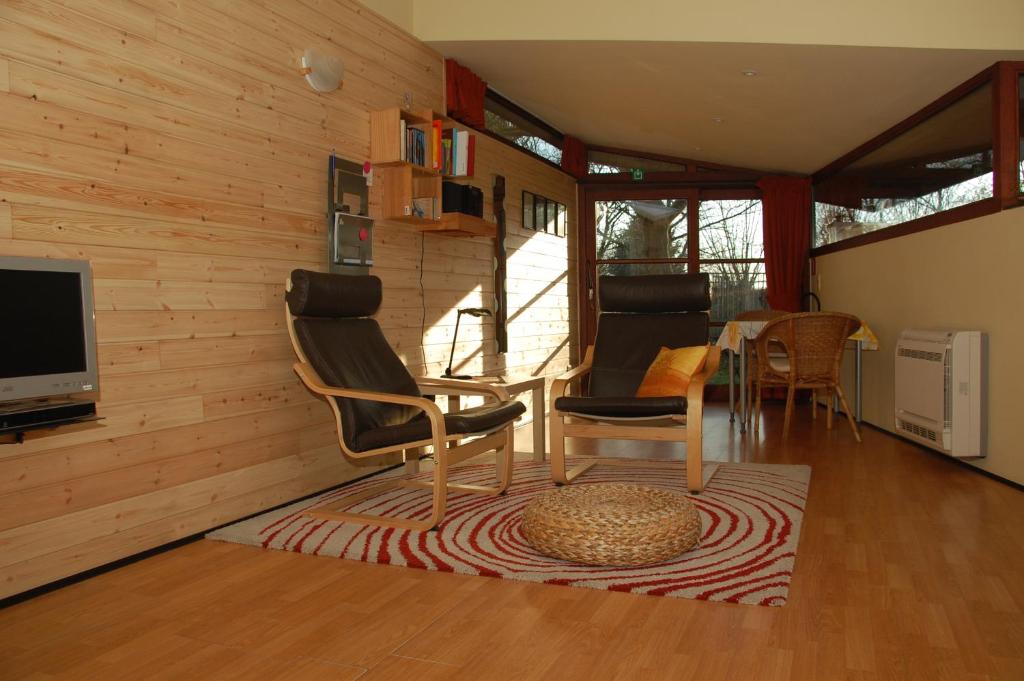 sala de estar con TV, sillas y mesa en Vakantiestudio 'Kleine Johannes', en Duffel