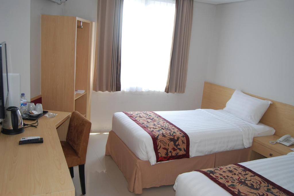 Postel nebo postele na pokoji v ubytování Bekizaar Hotel Surabaya