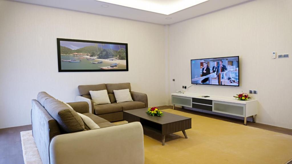 Casuarina Pangkor في بانكور: غرفة معيشة مع أريكة وتلفزيون بشاشة مسطحة