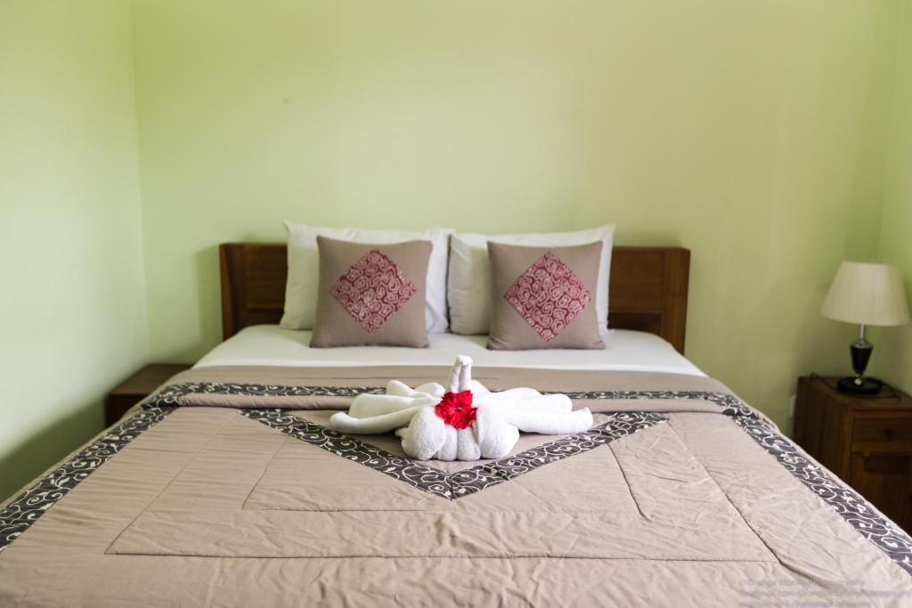 two towels are sitting on a bed with pillows at Sudiana House in Ubud
