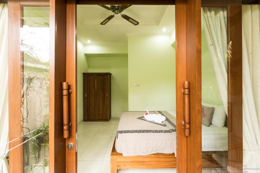 a bedroom with a bed and a glass door at Sudiana House in Ubud