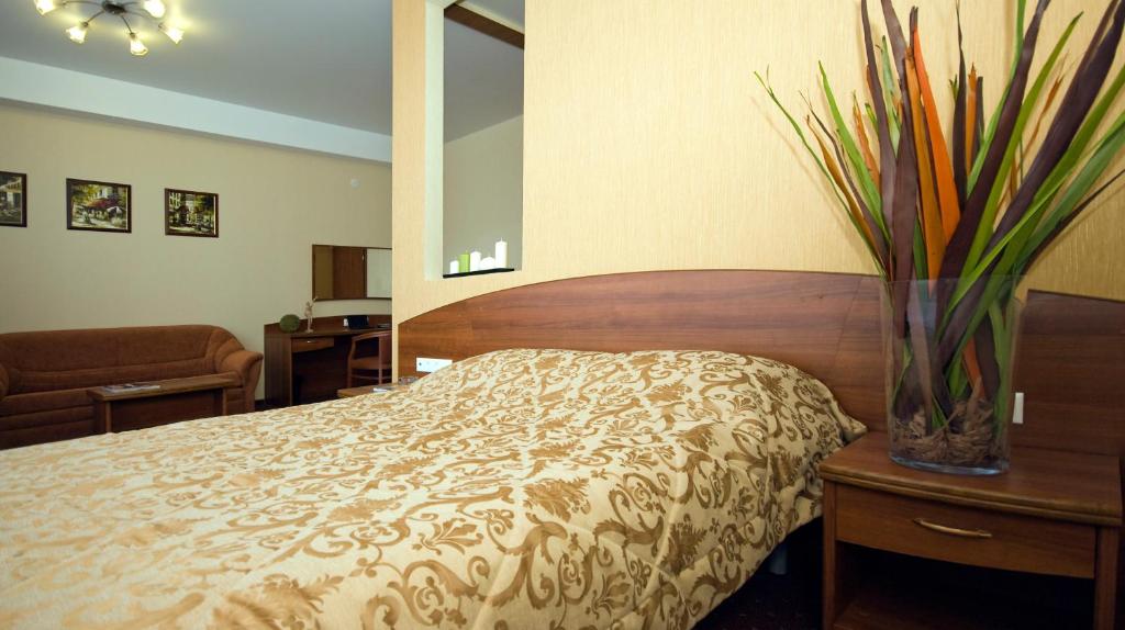 a bedroom with a bed and a vase on a table at Apart Hotel in Ryazan