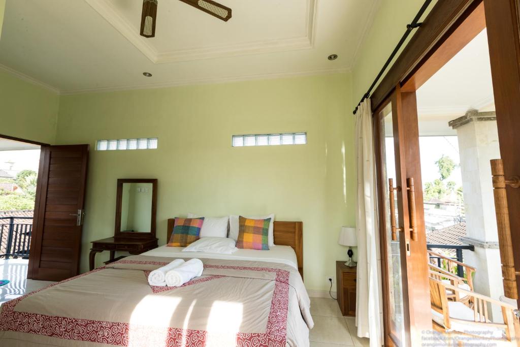 a bedroom with a bed and a balcony at Sudiana House in Ubud