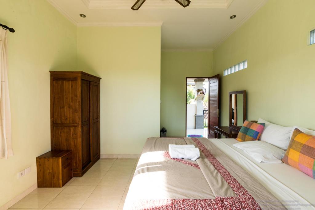 a bedroom with a large bed and a wooden cabinet at Sudiana House in Ubud