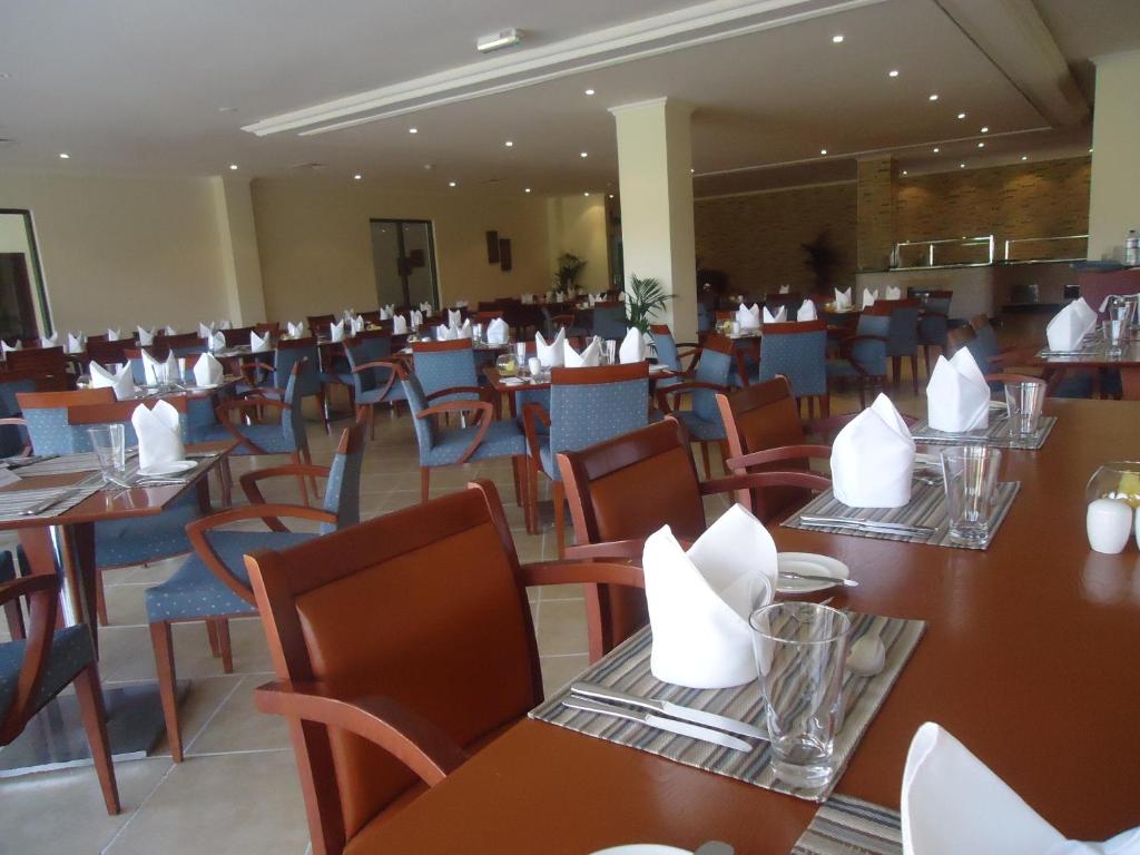 a restaurant with tables and chairs with napkins on them at Dhafra Beach Hotel in Jebel Dhanna
