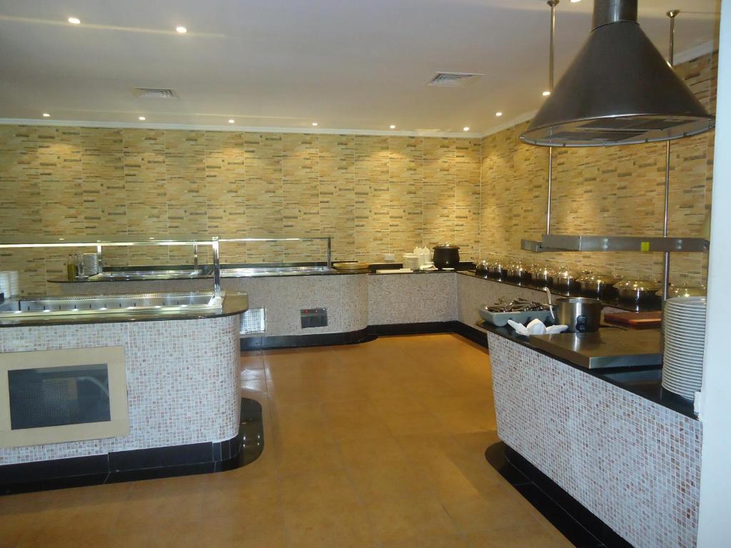 a large kitchen with a counter in a restaurant at Dhafra Beach Hotel in Jebel Dhanna