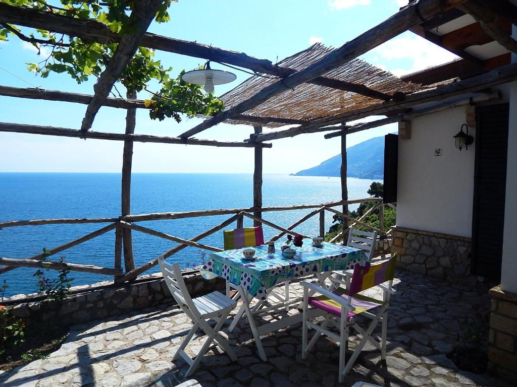 una mesa y sillas en un patio con vistas al océano en Amalfi View Cottage, en Amalfi