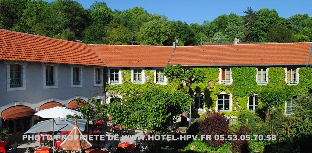 a building with an orange roof and a group of tables at Logis Hostellerie du Perigord Vert in Brantôme