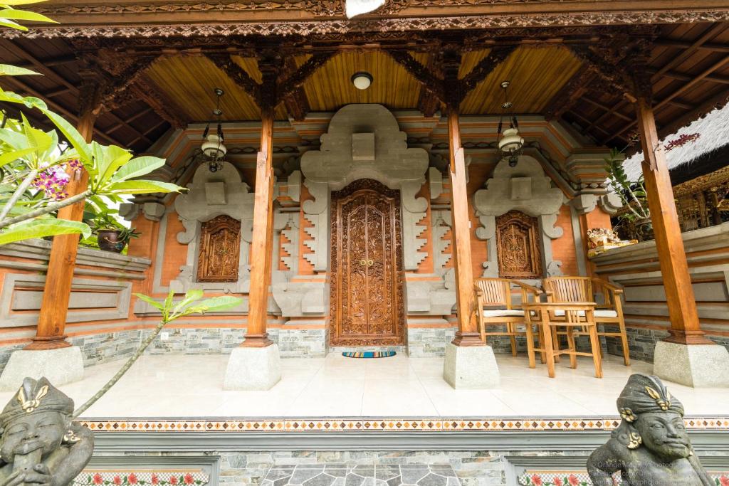a building with a large door and chairs in it at Sudiana House in Ubud