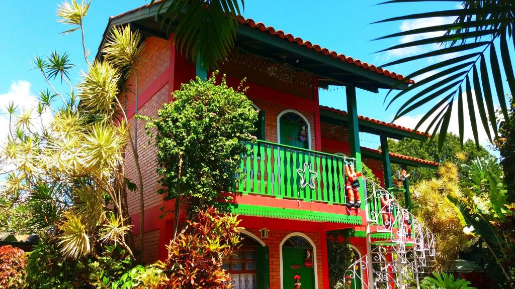 una casa roja con un balcón en el lateral. en Pousada Estrela do Mar, en Florianópolis