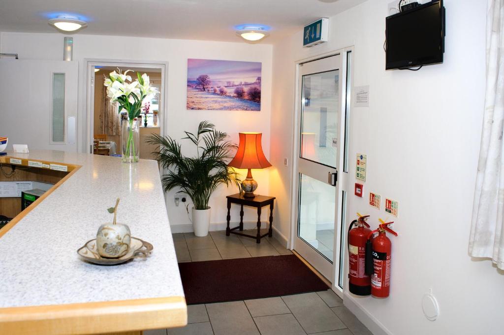 a kitchen with a counter with a vase of flowers at Almond Tree Hotel in Bicester