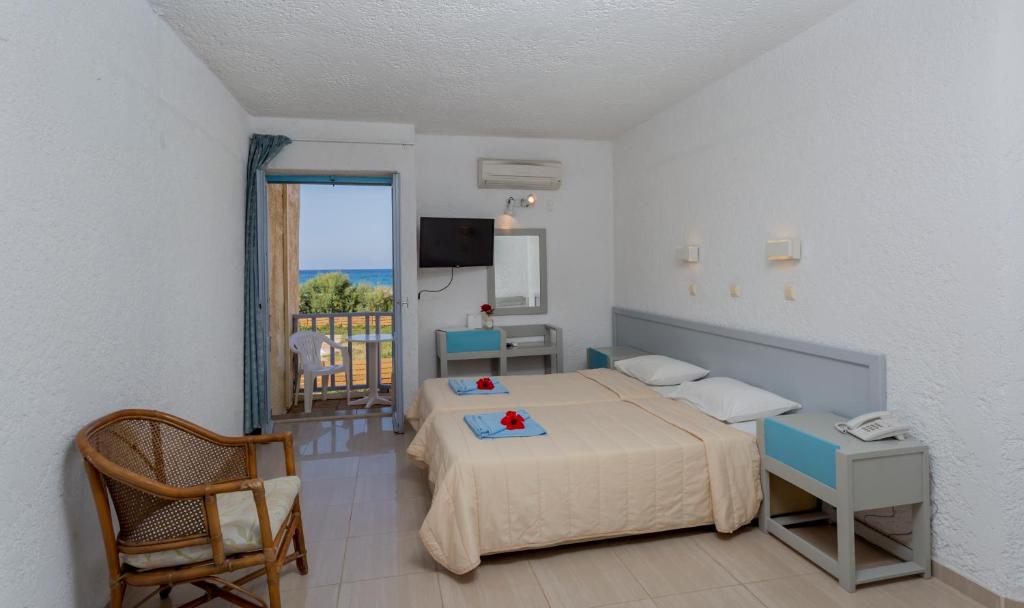 um quarto de hotel com uma cama e uma varanda em Dessole Dolphin Bay - All Inclusive em Amoudara Herakliou