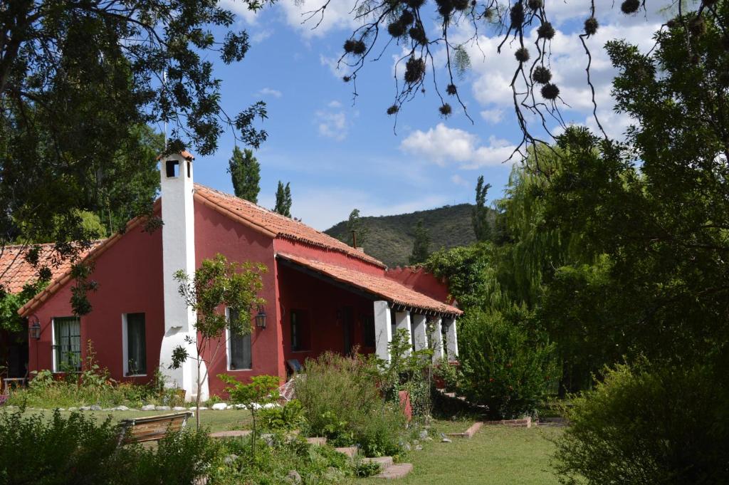 una casa roja y blanca con árboles y arbustos en Hostería Bello Horizonte en La Paz