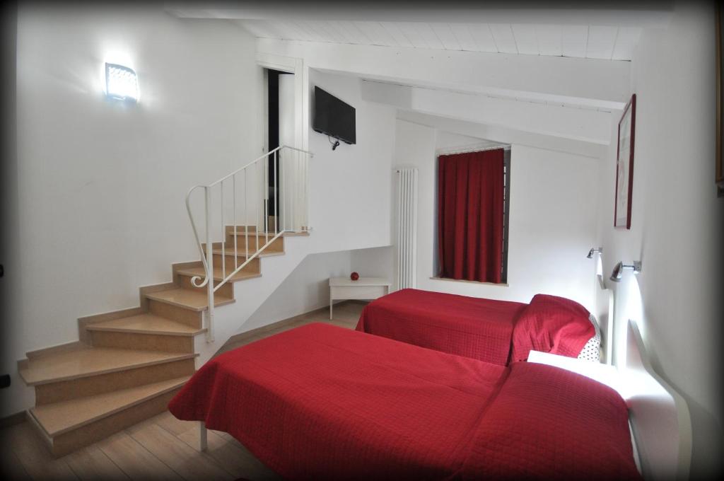 グラヴィーナ・イン・プーリアにあるLa Dimora dell' Architettoのベッドルーム1室(赤いベッド1台、階段付)