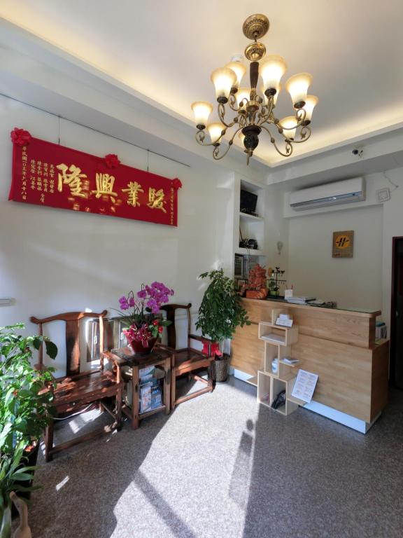 a living room with a chandelier and a table at Long Zhi Yue Hotel in Nangan