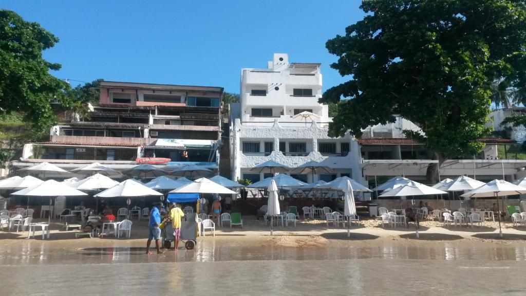 two people standing in the rain on a beach with umbrellas at Habana Beach Flat in Natal