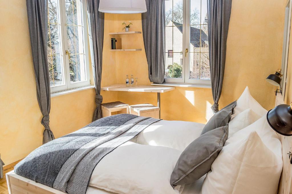 a bedroom with a bed and a sink and windows at K-Hotel (Grüner Baum) in Überlingen