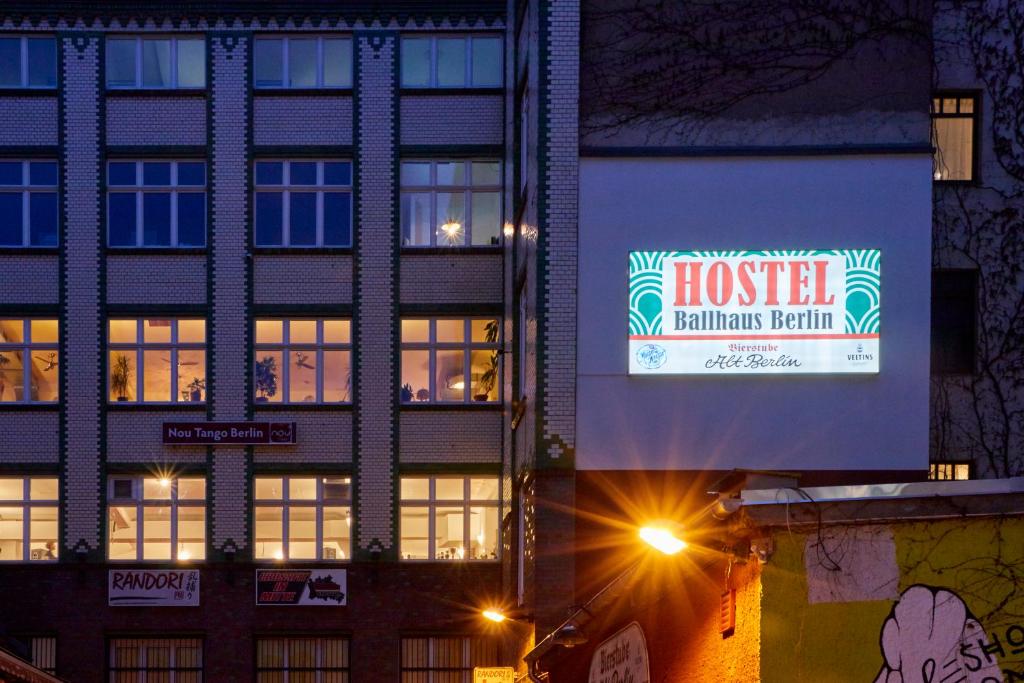 un edificio con un cartello per un hotel di notte di Ballhaus Berlin Hostel a Berlino