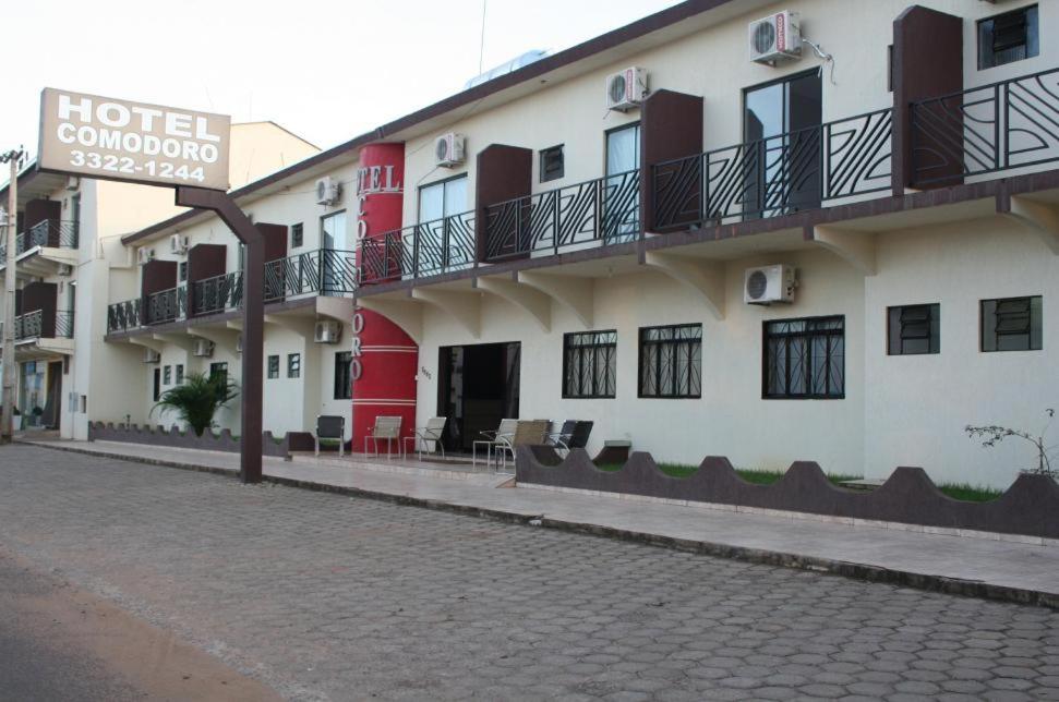 ein Hotelgebäude mit Hotelschild neben einer Straße in der Unterkunft Hotel Comodoro in Vilhena