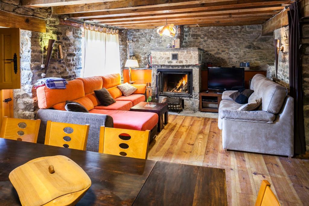 sala de estar con sofá y chimenea en Casa Dorondón, en Lasaosa